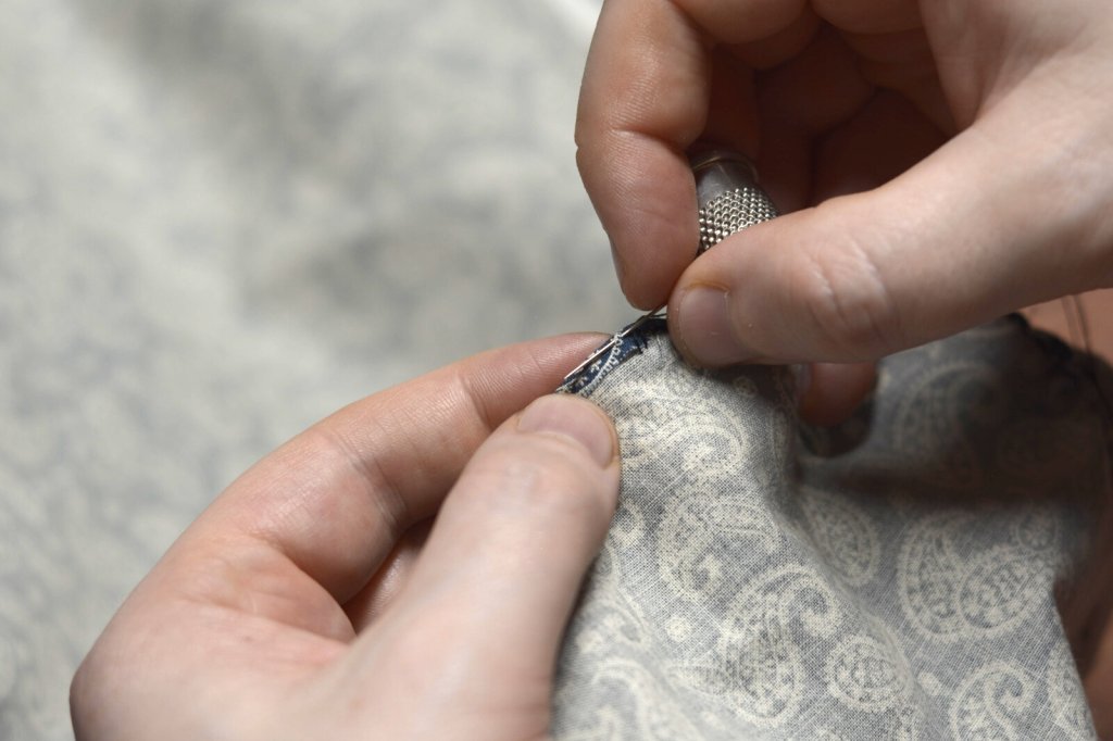 Take a stitch in the folded fabric.